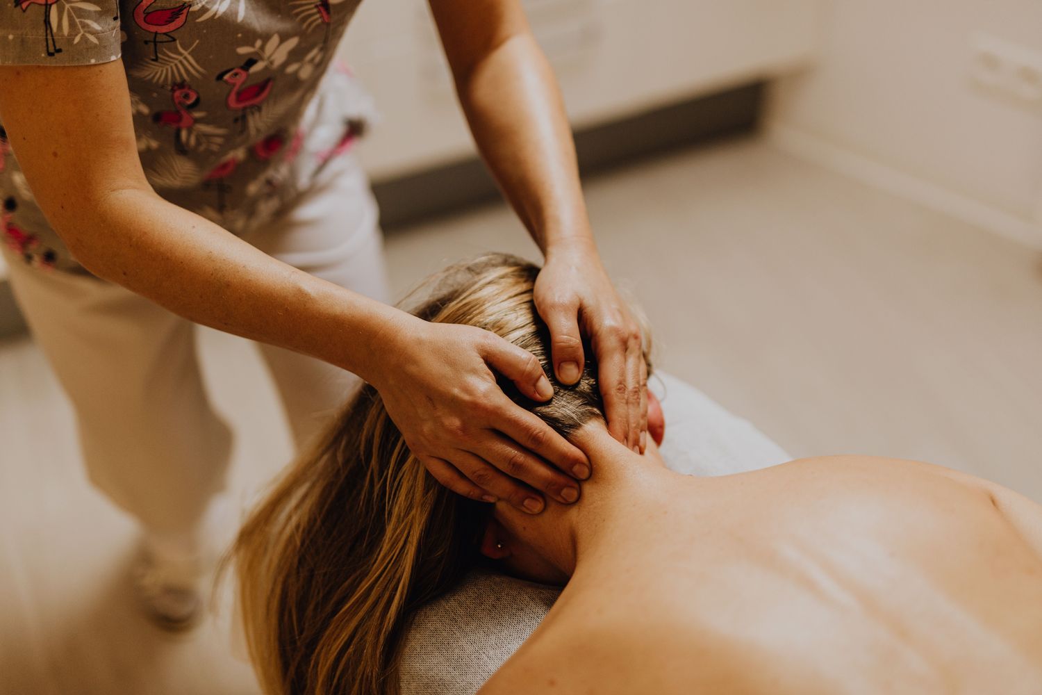 Praticienne massant la nuque d'une cliente allongée